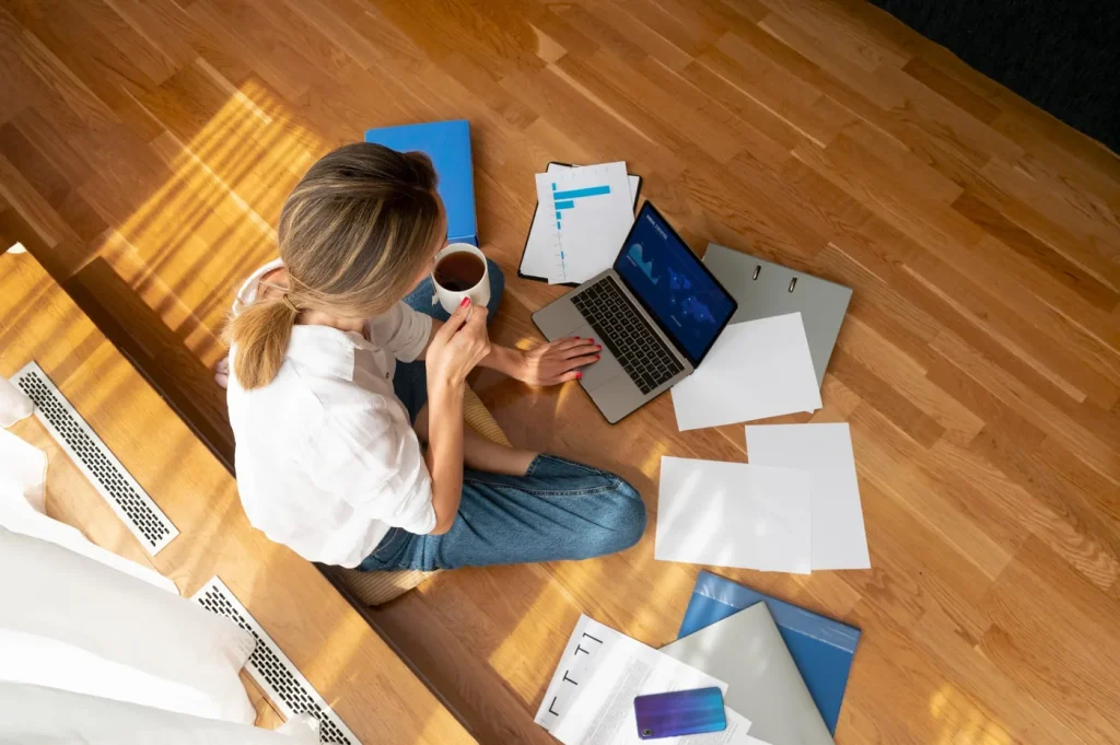 Persona adulta organizando tareas con un portátil y documentos