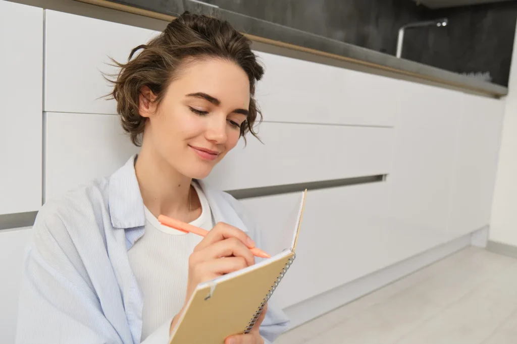 Mujer escribiendo en una libreta en un entorno cotidiano