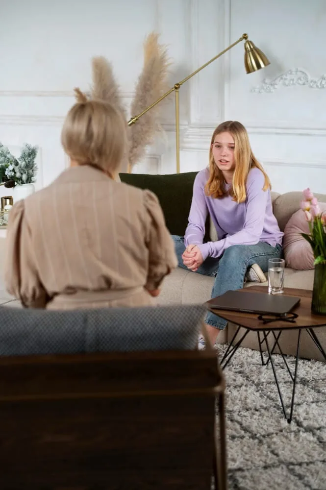 Adolescente hablando con una psicóloga durante una sesión en consulta.